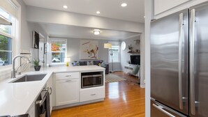 A modern kitchen with stainless steel appliances, a built-in oven, and a large island. - Bay Area Charming 1938 Art Deco Duplex (Alameda)