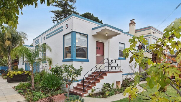 A two-story house with a red door, blue trim, and a small front porch. - Bay Area Charming 1938 Art Deco Duplex (Alameda)