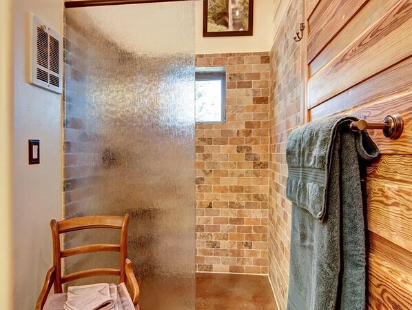 A bathroom with a shower, a wooden chair, a towel rack, and a small window. - Borders Cog Railway, Incline, & Barr Trail ~ Closest STR to Pikes Peak Summit! (Manitou Springs)