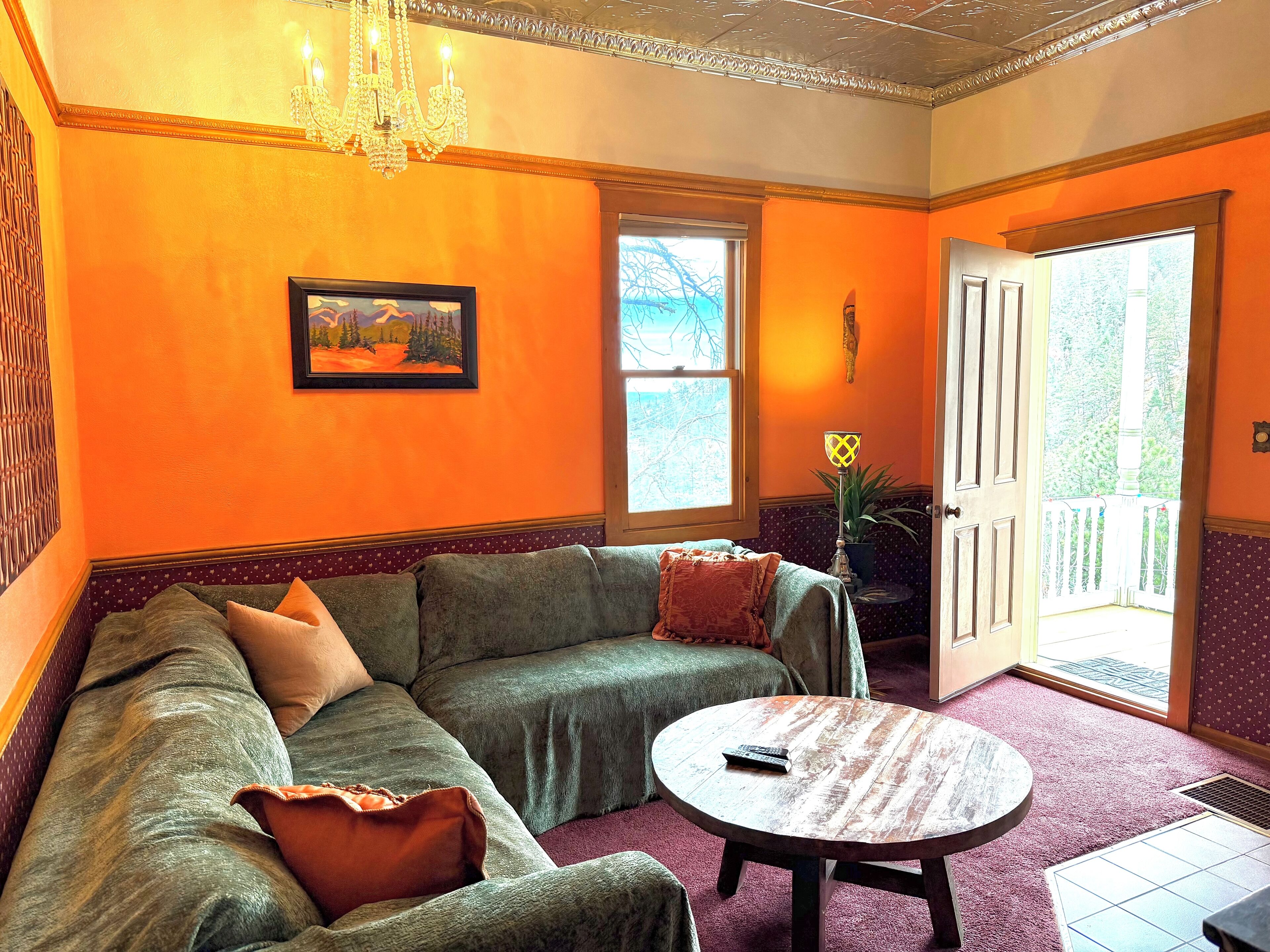 A living room with a sectional sofa, a round coffee table, and a chandelier.