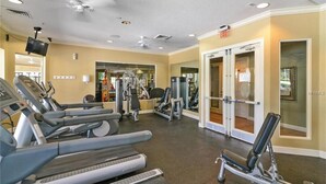 A gym with treadmills, weight machines, and a mirror wall. - Tinkerbell's Hideaway 2.5 miles from Disney/pool/NO resort fees/FREE parking (Kissimmee)