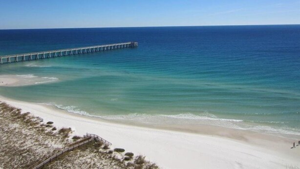 A beach with a long pier extending into the ocean. - PENTHOUSE 17th floor w. free Beach Service (chairs/umbrella) included! (Navarre)