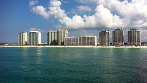 A beachfront hotel with multiple high-rise buildings, a sandy beach, and a clear blue sky. - PENTHOUSE 17th floor w. free Beach Service (chairs/umbrella) included! (Navarre)