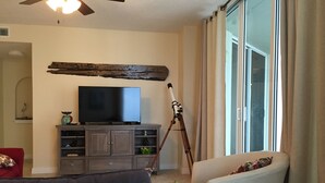 A living room with a television on a wooden cabinet, a telescope, and two sofas. - PENTHOUSE 17th floor w. free Beach Service (chairs/umbrella) included! (Navarre)