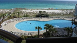 A pool with a view of the ocean, surrounded by a sandy beach and palm trees. - PENTHOUSE 17th floor w. free Beach Service (chairs/umbrella) included! (Navarre)