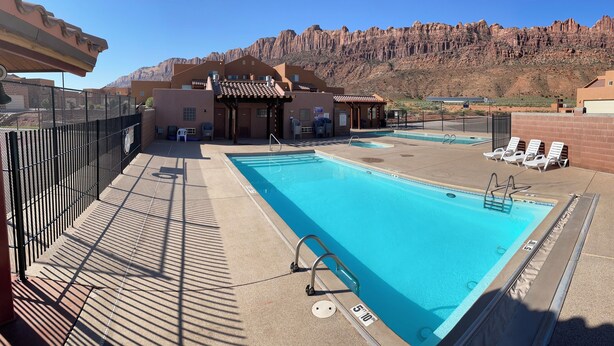 A rooftop pool with a view of a mountainous landscape, surrounded by buildings with a modern design. - 6A4 Views from Patio, Two Car Garage, Community Pool & Hot Tub (Moab)