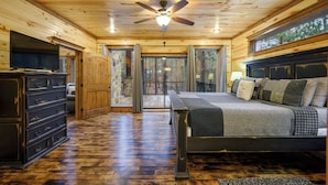 A wooden cabin interior with a bed, dresser, and a ceiling fan. - 4 Bedroom 3.5 Bath-Pickleball/Basketball Court, Game Room, Hot Tub & Playground (Broken Bow)