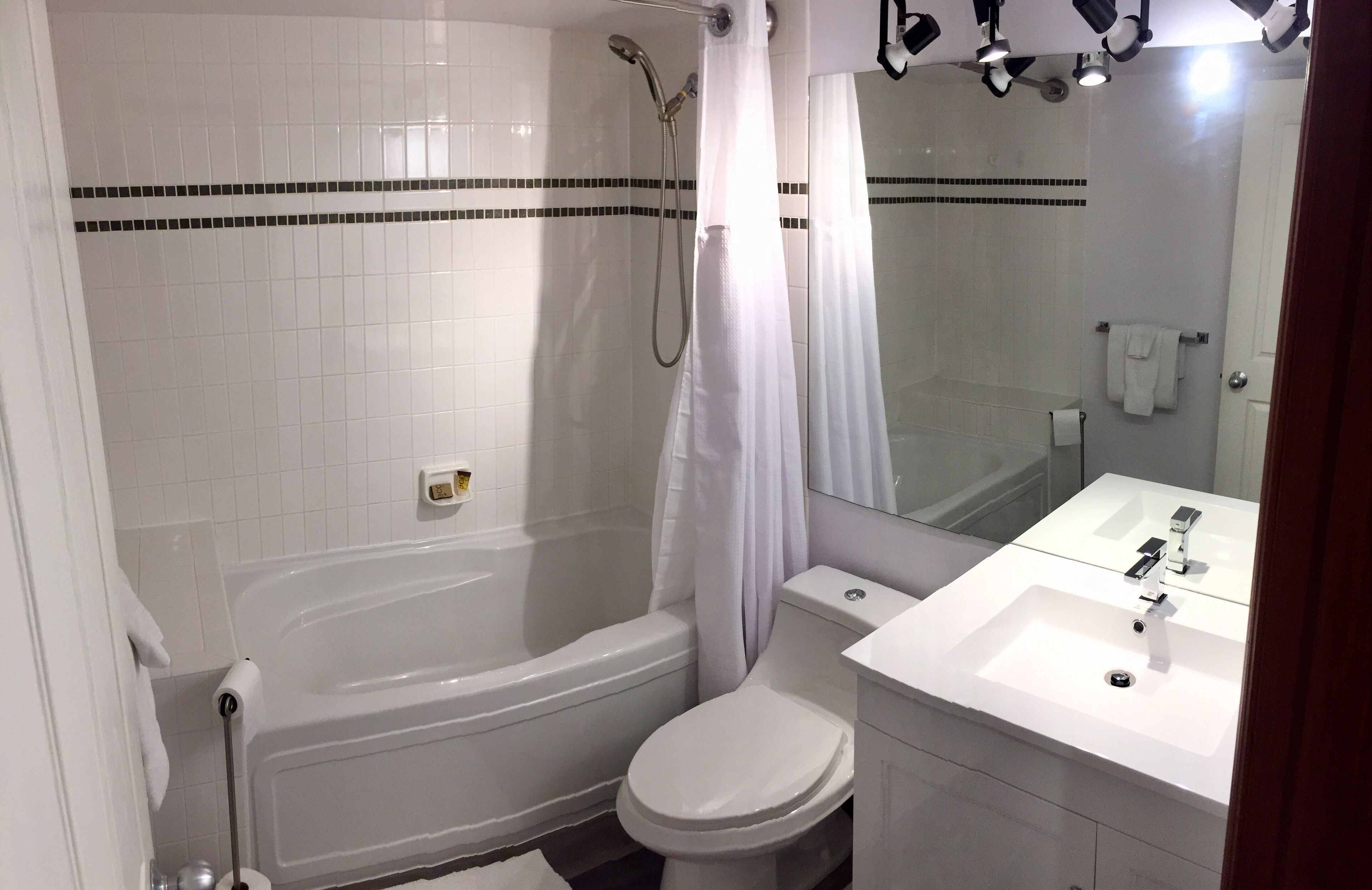 Une salle de bain avec une baignoire blanche, des toilettes et un lavabo.