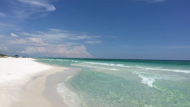Ein Strand mit klarem türkisblauem Wasser und einem sandigen Ufer.