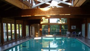 An indoor swimming pool with wooden beams and large windows. - Private Room with Attached Sun Room and Covered Deck (Aptos)