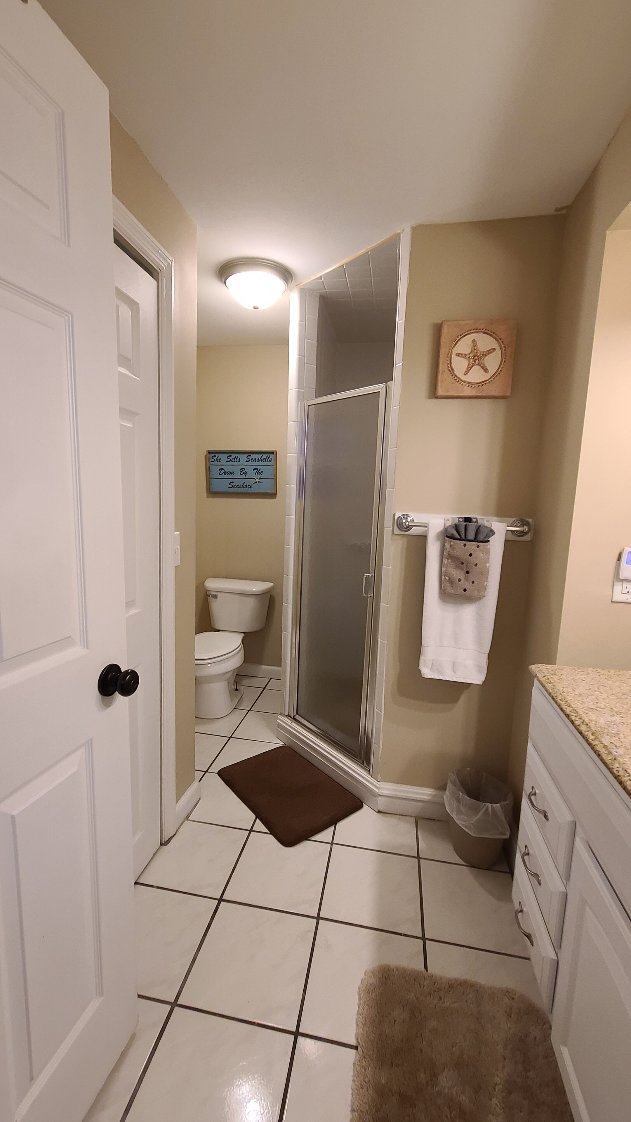 A bathroom with a shower, toilet, and sink.