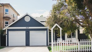 A two-story house with a garage numbered 617, a white picket fence, and a tree in the front yard. - Beachy and Clean!  White Water Views! (Oceanside)