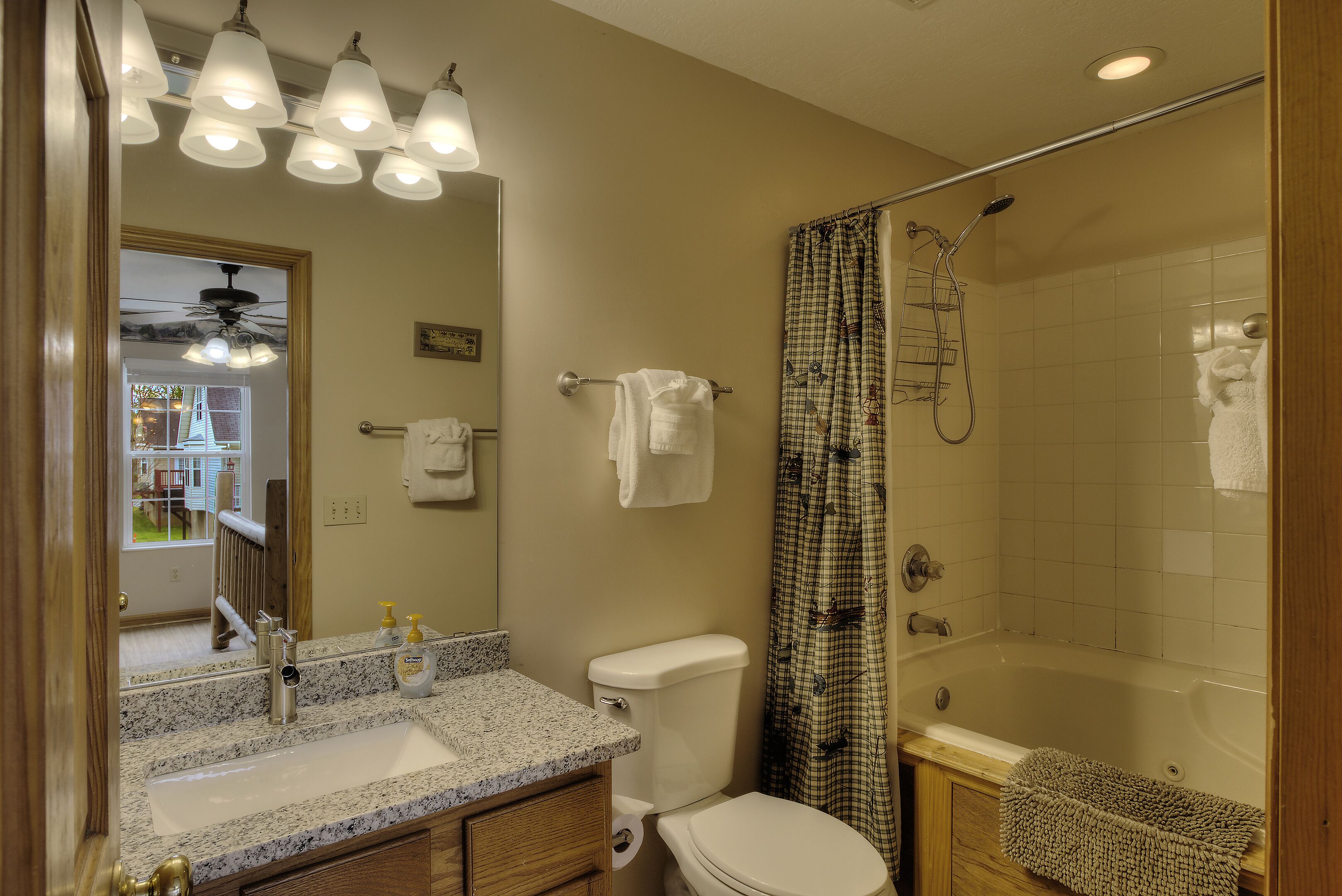 A bathroom with a sink, toilet, and shower area.