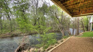 A riverside view with a wooden deck and a stone pathway leading to a building. - Amy's Waterfront Blessing w/ Hot Tub, Arcade , & Fishing 2 King Master Suites (Pigeon Forge)