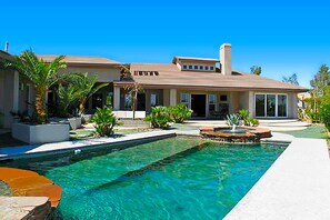 Une maison moderne dotée d’une piscine, d’un patio et d’un jardin bien entretenu.