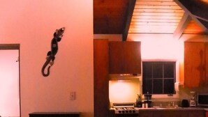 Acogedor dormitorio en ático con cama, sofá y zona de cocina con estufa y armarios.