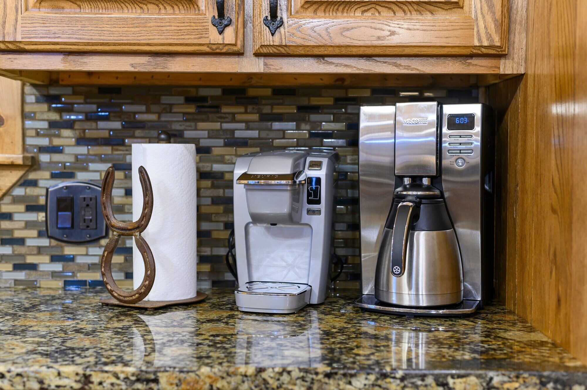A kitchen with a coffee maker, a paper towel holder, and a microwave.