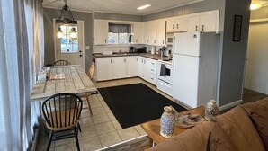 Un espace de vie compact comprenant un coin repas, une kitchenette et un canapé.