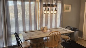 Un coin repas avec une table en bois, des chaises et un lustre.