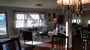 Una sala de estar con un sofá, sillones, una mesa de centro y una araña.