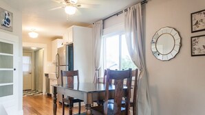 A dining area with a table and chairs, a ceiling fan, a refrigerator, and a window with curtains. - *NEW* Downtown Modern Nostalgia, completely updated and convenient (Bend)