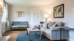 A living room with a sofa, a coffee table, and a lamp. - *NEW* Downtown Modern Nostalgia, completely updated and convenient (Bend)