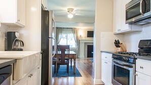 A modern kitchen with white cabinets, a stainless steel stove, and a microwave. - *NEW* Downtown Modern Nostalgia, completely updated and convenient (Bend)