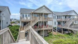 A multi-story beachfront property with wooden decks and balconies, featuring a central staircase and outdoor seating area. - "Comes A Time" Oceanfront - Best Surf City location, walk to everything! (Surf City)