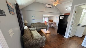 A living room with two patterned sofas, a wooden coffee table, and a ceiling fan.