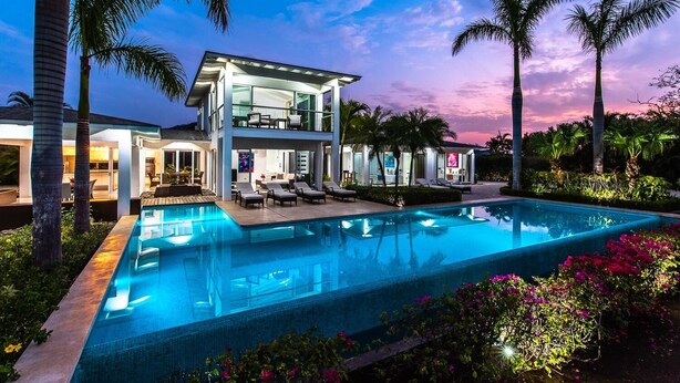 A modern two-story house with a swimming pool, surrounded by palm trees and lush greenery. - Luxurious villa with panoramic views and breathtaking private infinity pool !!! (Tamarindo)
