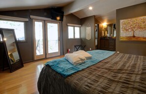 A bedroom with a bed, a dresser, a mirror, and a painting on the wall.