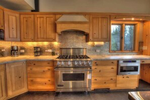 Une cuisine avec des meubles en bois, une cuisinière en acier inoxydable et un four.