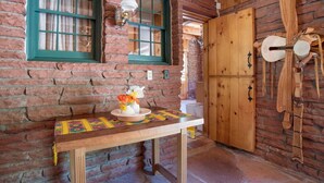 Um interior rústico de madeira com uma mesa de madeira, um vaso com flores e uma porta de madeira.
