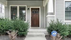 A house with a front door, two windows, and a small porch. - 1-Story Family Home,  Fenced Yard, Grill, Parking | Sleeps 10, 5 Mins to Five Points & Nissan Stadium, Smart TVs, Pet-Friendly Yard, Patio for BBQs, Ideal Nashville Getaway for Families, 24 Hr Hospitality (Nashville)
