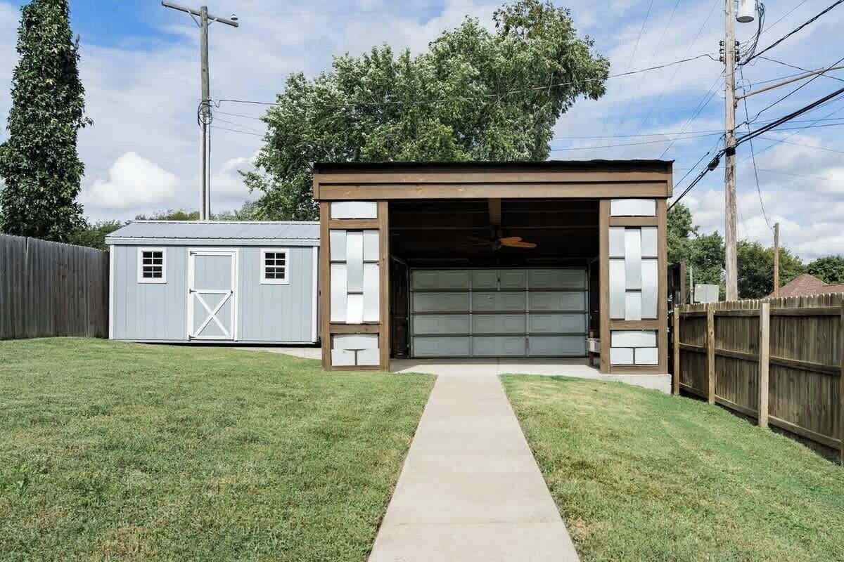 A garage with a clear entrance and a small adjacent shed.