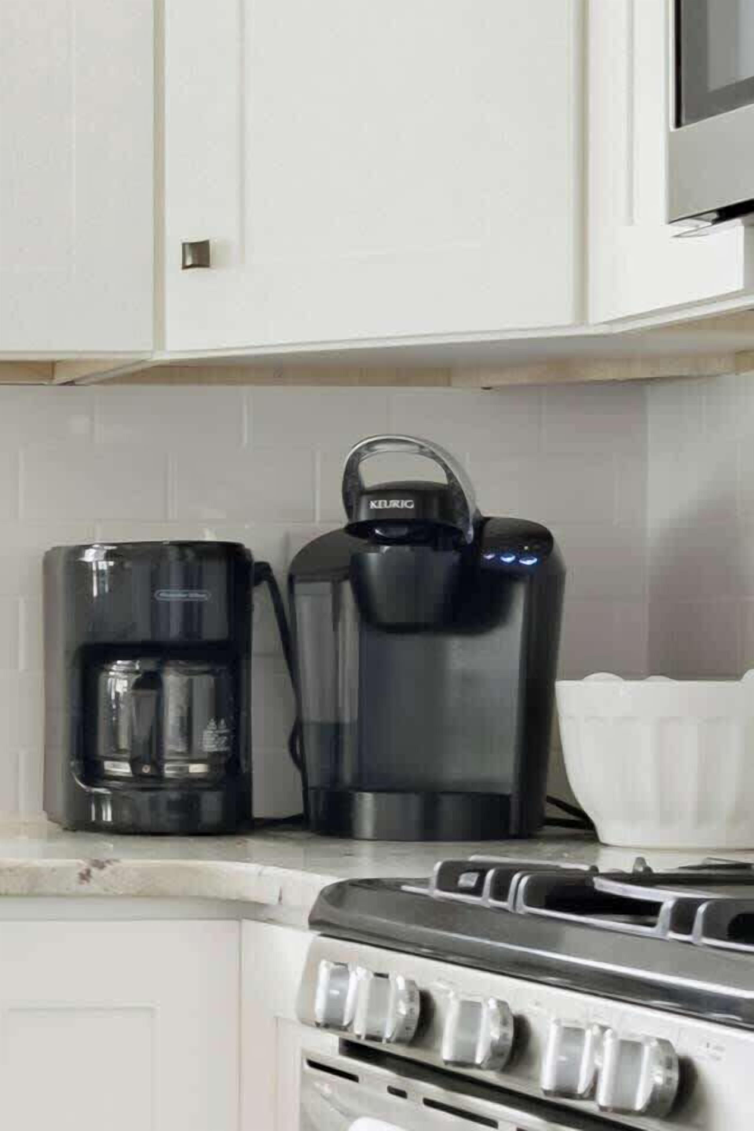 Une cuisine équipée d’une machine à café, d’une bouilloire et d’une cuisinière.
