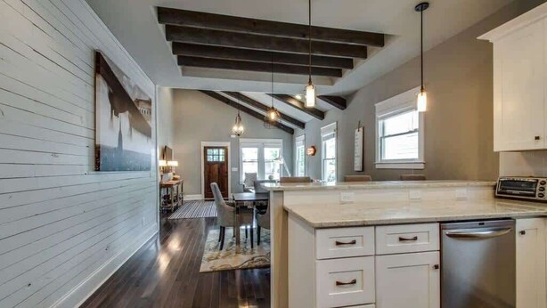 A modern kitchen with white cabinetry, a central island, and pendant lighting. - 1-Story Family Home,  Fenced Yard, Grill, Parking | Sleeps 10, 5 Mins to Five Points & Nissan Stadium, Smart TVs, Pet-Friendly Yard, Patio for BBQs, Ideal Nashville Getaway for Families, 24 Hr Hospitality (Nashville)
