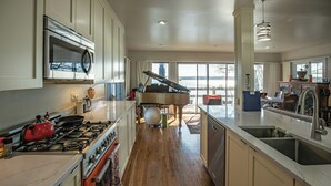 A spacious kitchen with a piano, large windows, and a view of the outdoors. - Lakeside fling! Same day bookings accepted with a VRBO reservation. Terms apply (Canandaigua)