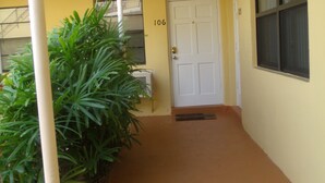 A corridor with a white door marked 106, a window with blinds, and a potted plant. - Studio, Steps to Beach/Broadwalk Pool and Free Parking. Beach Terrace Building (Hollywood)