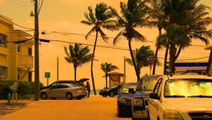 A street with parked cars, palm trees, and a building with balconies. - Studio, Steps to Beach/Broadwalk Pool and Free Parking. Beach Terrace Building (Hollywood)
