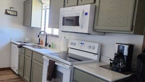 A compact kitchen with white appliances, green cabinets, and a wooden floor. - Get Out Of The Heat And Enjoy The Mountain Air,  Catch Trophy Trout, Relax (panguitch)