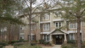 A multi-story building with a stone facade, a central entrance with a black door, and a number '1010' above the door. - WOW! 30% Off Until Oct. 1st | Walk to Ritz, Golf Front, 3 King Beds, Book Now (Greensboro)