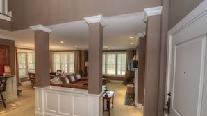 A spacious living area with a high ceiling, wooden flooring, and a central seating area with a sofa and chairs. - WOW! 30% Off Until Oct. 1st | Walk to Ritz, Golf Front, 3 King Beds, Book Now (Greensboro)
