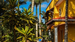 A yellow building with a red-tiled roof, surrounded by palm trees and tropical plants. - Private Luxury Villa 15,000 sq ft,kid friendly, Maid, pvt.Chef,24 h security (Playa Del Carmen)