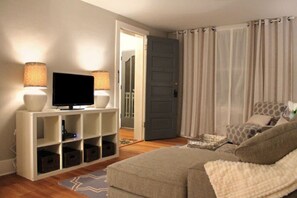 Relax in this inviting living room with a sofa, armchair, and TV.