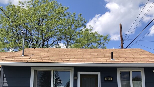 A single-story house with a dark blue exterior, a front door, two windows, and a small porch. - Convenient & Cozy Cottage On Newport Near River, Downtown & Drake Park (Bend)