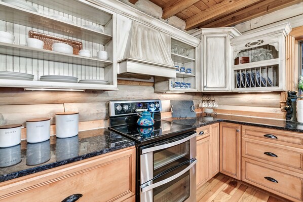 A kitchen with wooden cabinets, a stainless steel oven, and a granite countertop.