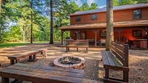 A rustic cabin with a covered patio, outdoor seating, and a fire pit. - Relax by Broken Bow Lake, your cozy 3-bedroom Hochatown retreat (Broken Bow)