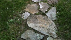 A stone pathway leading to a wooden deck.