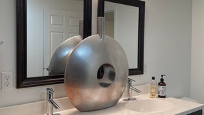 A bathroom with two sinks, a large mirror, and a modern faucet. - Downtown!  Great neighborhood!  Walk everywhere downtown!   (Anchorage)